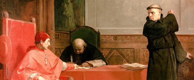 Illustration of Cardinal Cajetan, seated at a table and dressed in red robes, examining Martin Luther and his writings. Martin Luther is standing in front of the table. Behind the table is a scribe.