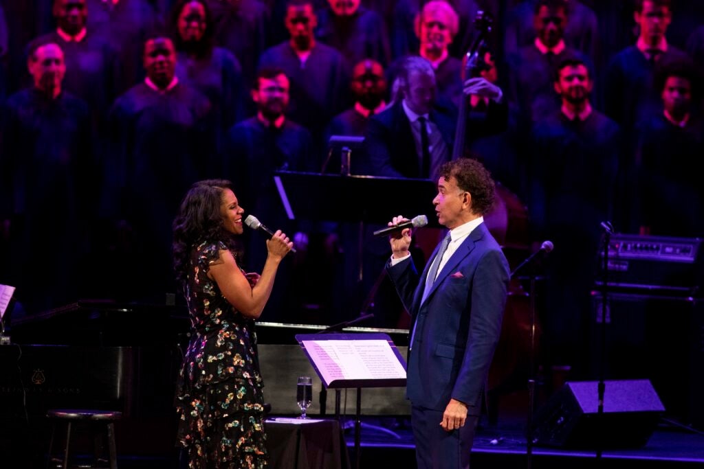 Audra McDonald and Brian Stokes Mitchell sing, facing each other, on the Kennedy Center stage, backed by a choir.