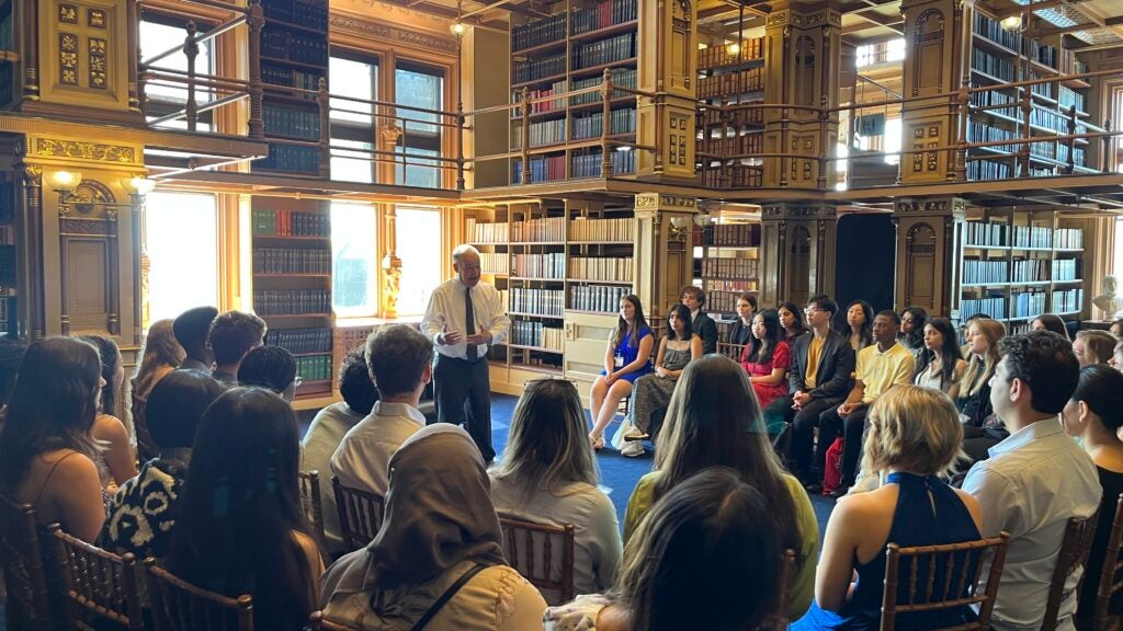 President DeGioia speaks to a group of seated students in Riggs Library