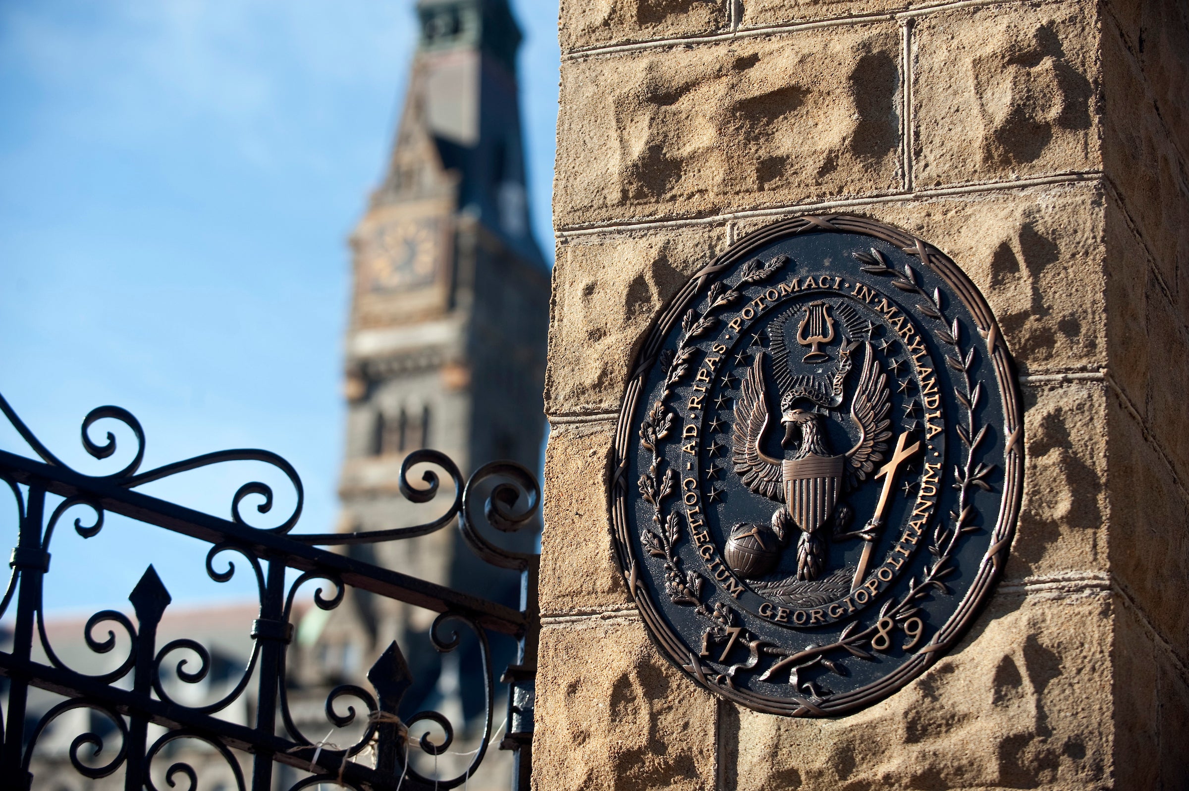The front gate of Georgetown University, featuring the university seal on a stone pillar.
