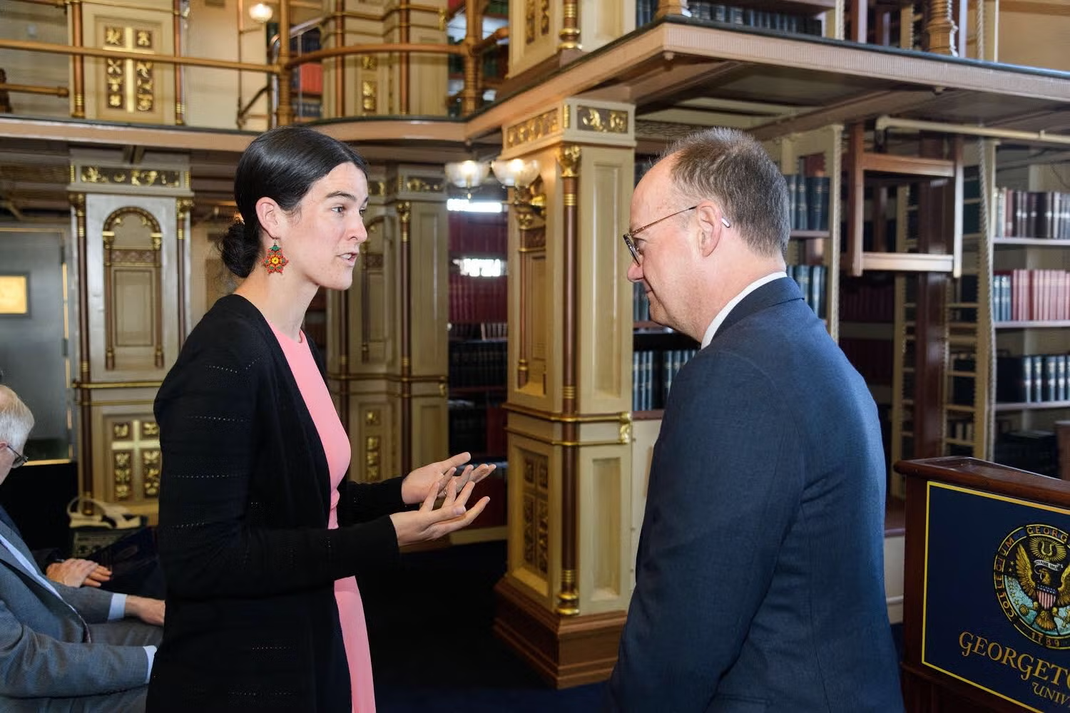 Joanna Foote Williams and then-presidient John J. DeGioia speak with each other in Riggs Library.