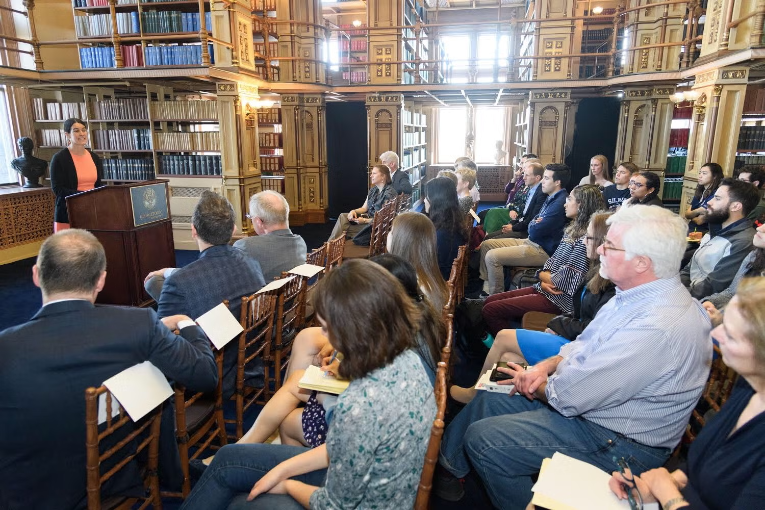 Wide shot of Joanna Foote Williams addressing a seated crowd in Riggs Library.