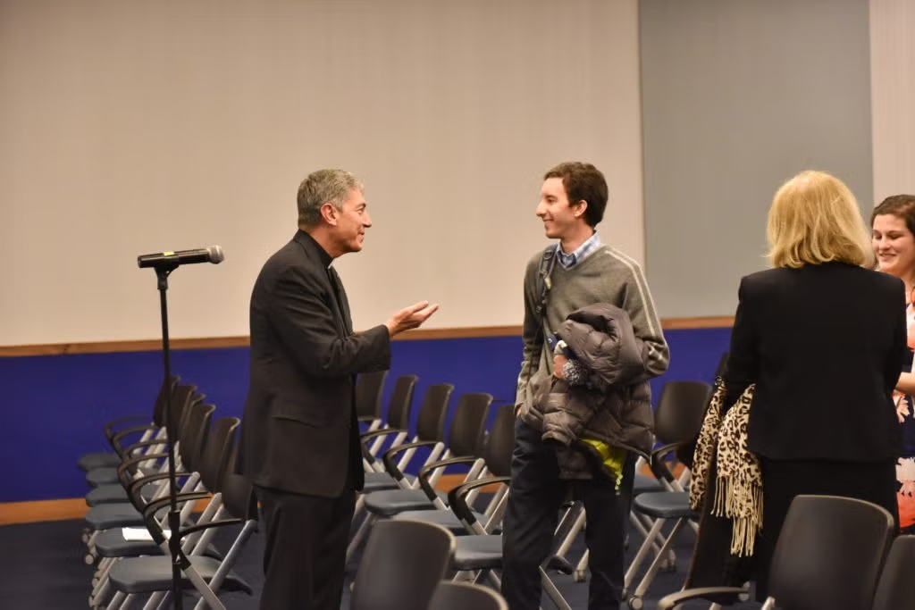Rev. Steve Katsouros, S.J. speaks with an audience member.