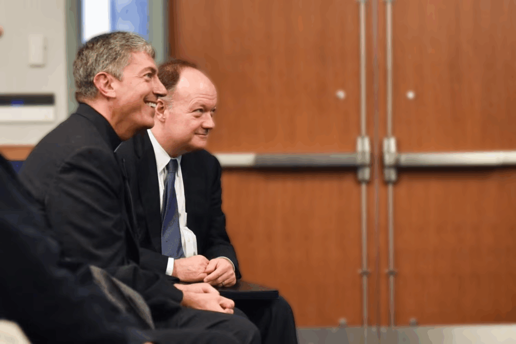 Rev. Steve Katsouros, S.J. and President John J. DeGioia sit together.
