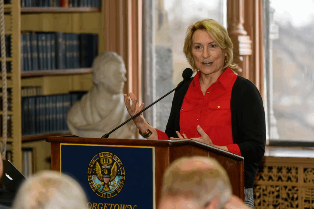 Dr. Nancy Tuchman, a white woman with short blonde hair, stands behind a podium in Riggs Library.