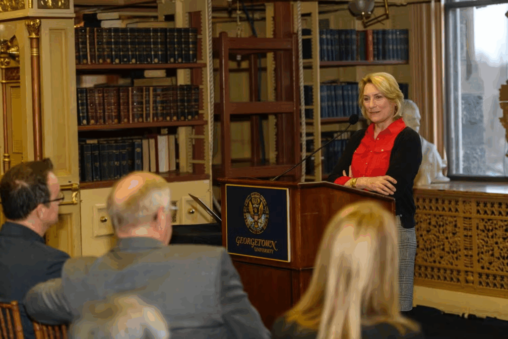 Dr. Nancy Tuchman speaks to a seated audience from behind a podium in Riggs Library.