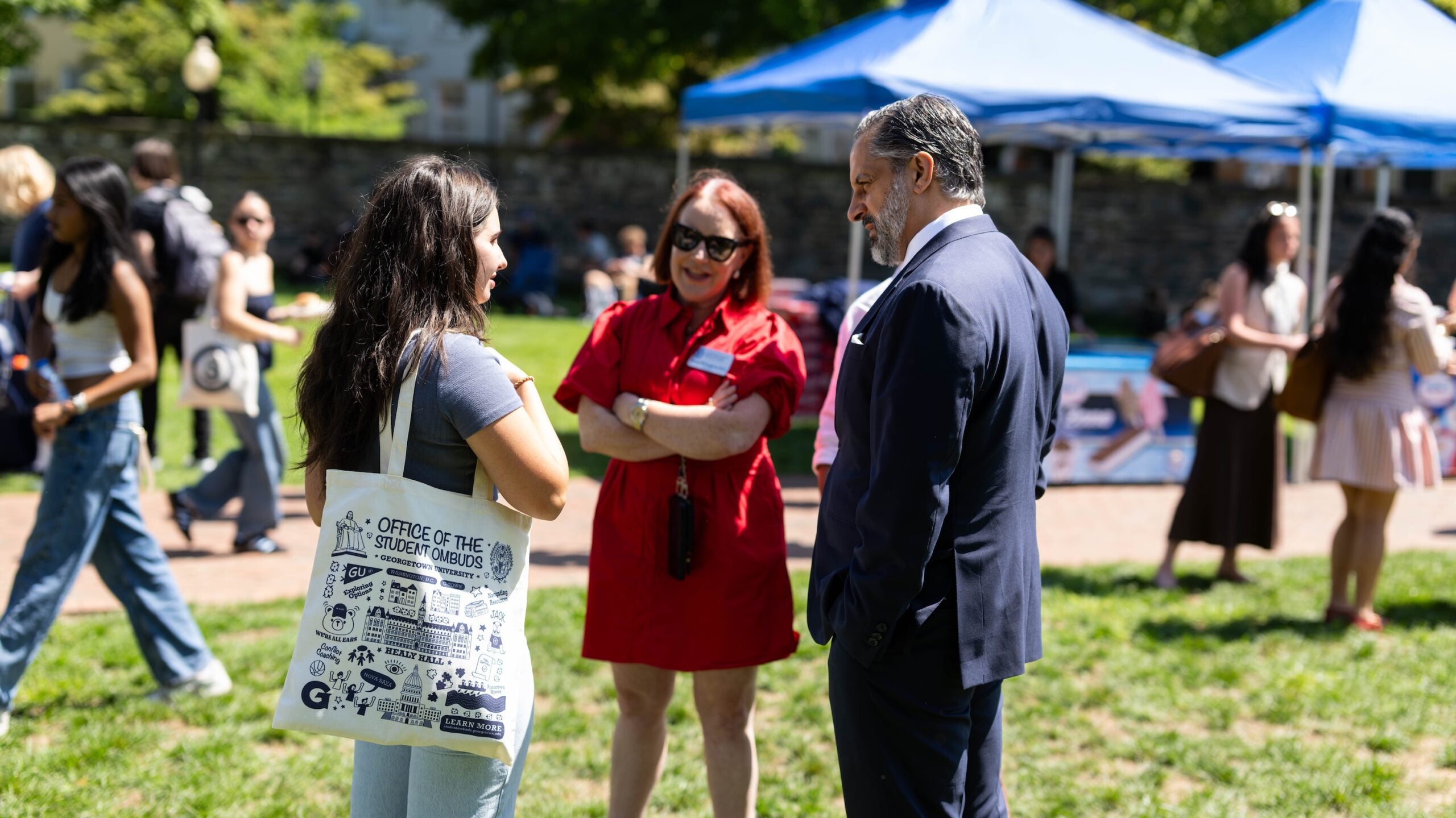 President Peñalver speaks a student and a staff member on Healy Lawn.