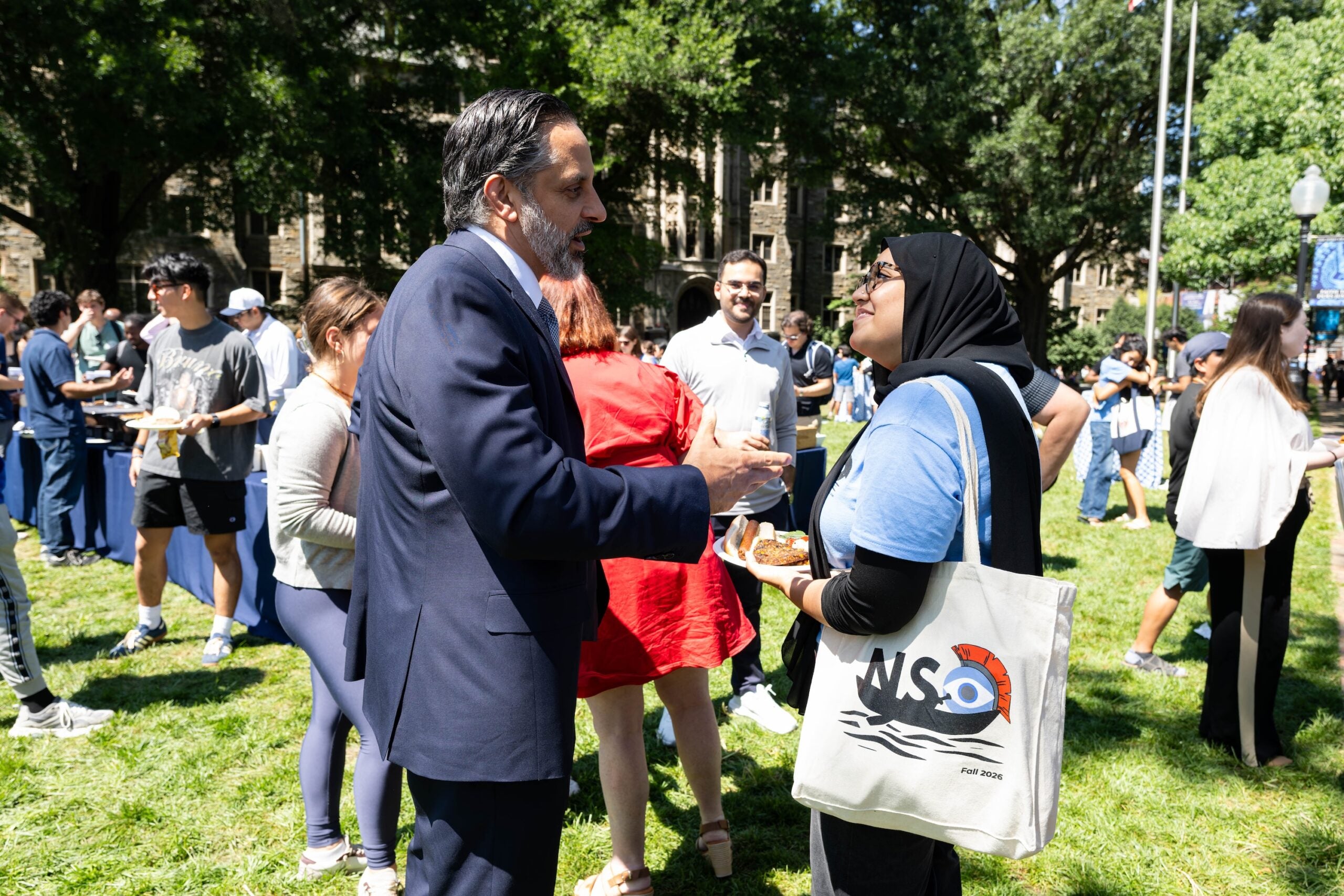 President Peñalver speaks with a female student among the crowd of barbecue attendees.