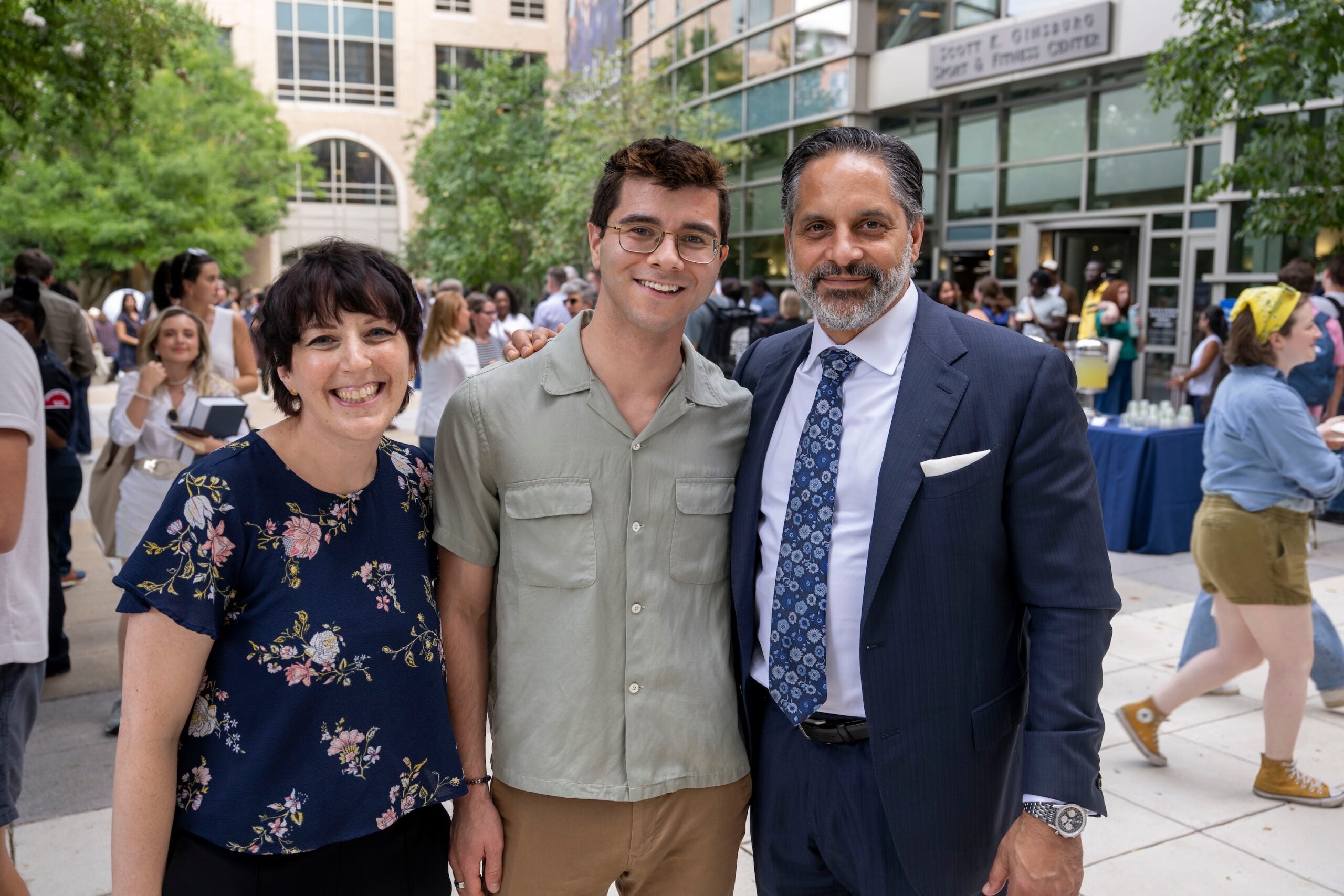 President Peñalver poses with two attendees at the Capital Campus Welcome Back Barbecue, outside the Eleanor Holmes Norton Green.